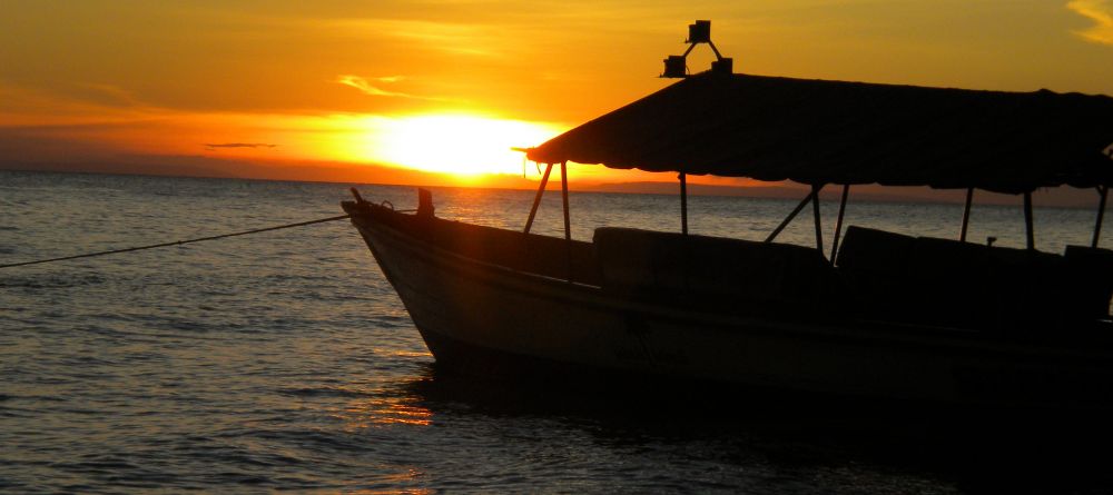 Boat silhouette at sunset at Gombe Forest Lodge, Gombe National Park, Tanzania - Image 8