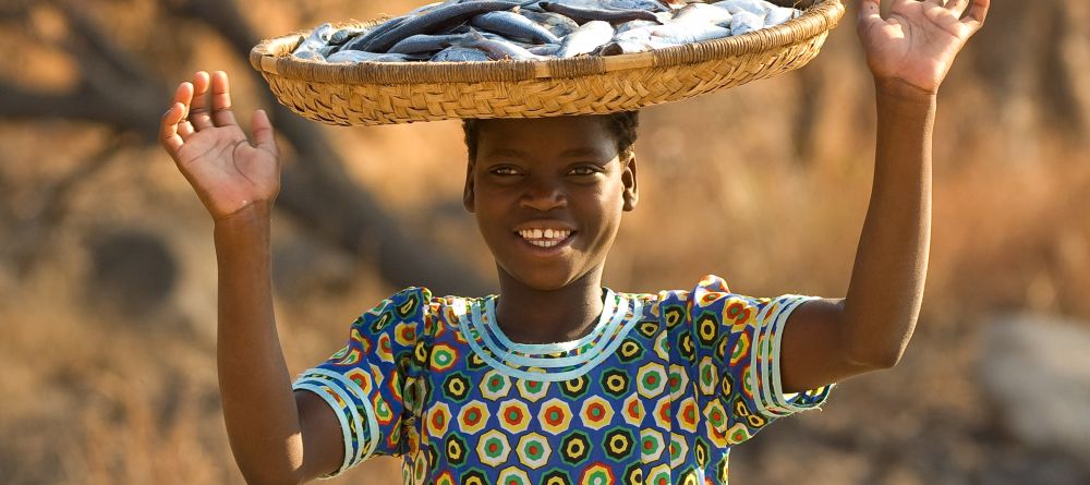 A local girl with preserved fish at Pumulani, Lake Malawi, Malawi - Image 7