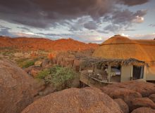 A suite with the bed and veranda overlooking the beautiful and unique landscape at Mowani Mountain Camp, Damaraland, Namibia