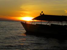 Boat silhouette at sunset at Gombe Forest Lodge, Gombe National Park, Tanzania