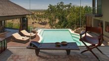 Lounge by a private pool overlooking a herd of elephants at the watering hole at The Four Seasons Safari Lodge, Serengeti National Park, Tanzania