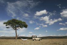 Relaxing in a hammock under the blue skies at Naibor Camp, Masai Mara National Reserve, Kenya