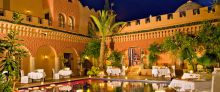 Poolside dining in the evening at Kasbah Tamadot, Atlas Mountains, Morocco