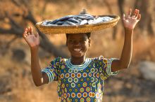 A local girl with preserved fish at Pumulani, Lake Malawi, Malawi