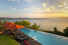 The sun sets over the pool at Pumulani, Lake Malawi, Malawi